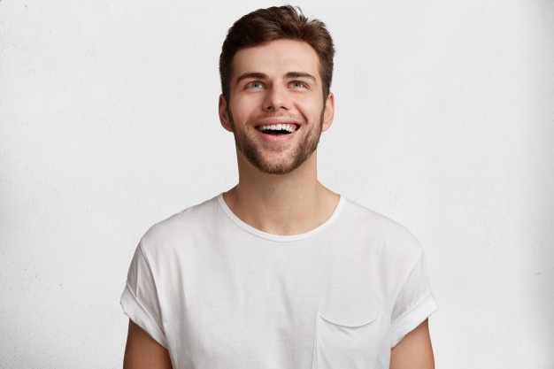 cheerful-young-handsome-guy-casual-t-shirt-isolated-white-studio-background-notices-something-pleasant-ceiling-expresses-positive-emotions-feelings-facial-expressions-concept_273609-3425
